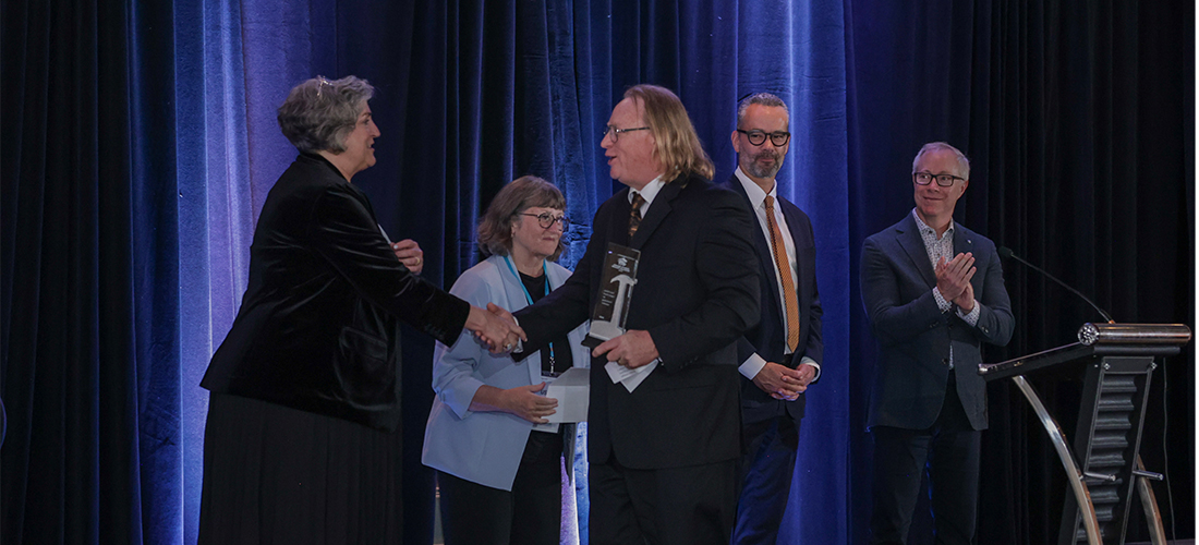 person accepting an award on a stage